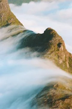 Clouds waterfall over mountain peak landscape Travel aerial view wilderness n Stock Photos