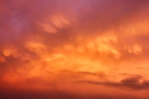 The clouds were now the orange of the setting sun Stock Photos