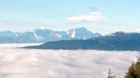 Clouds as white as sour cream, beautiful mountains and the tips of the Stock Footage 256237979