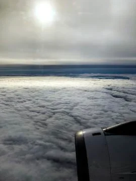 Cloudscape from above the clouds view from a plane window. Stock Photos