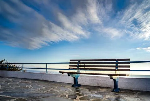 Cloudscape and bench with view in Rafina city, Greece Stock Photos