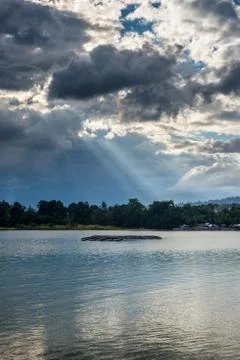 Cloudscape and sunbeams on lake Foto stock
