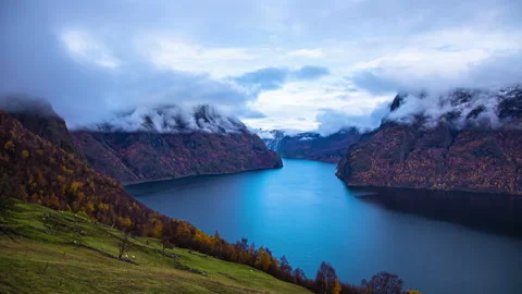 Cloudscape on the cliffs overlooking a deep fjord with sheep on the Stock Footage 211794817