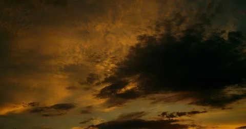Cloudscape with darkened altocumulus clouds that hover below the marmalade sky. Stock Photos