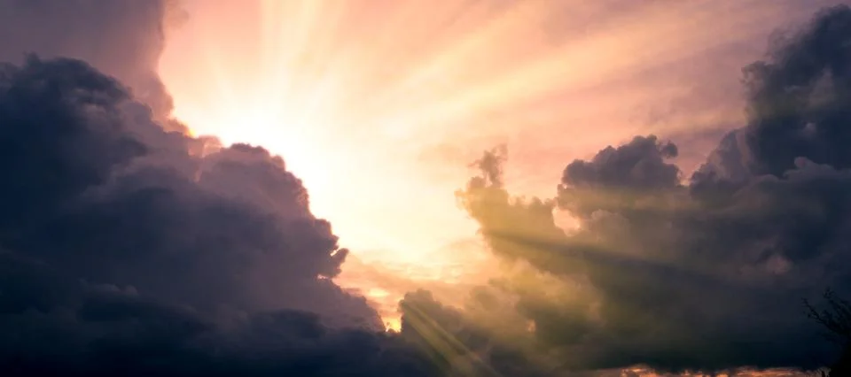 Cloudscape image of dark stormy clouds in blue sky with sun beam. The rays of Foto stock