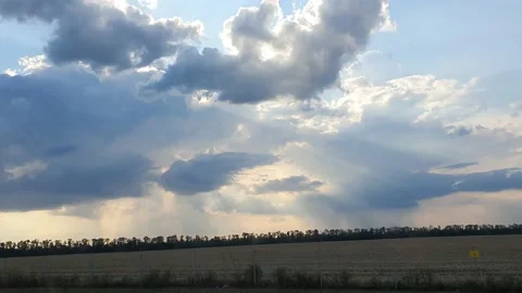 Cloudscape with large, building clouds and sunrise breaking through cloud mass Video stock 163654553