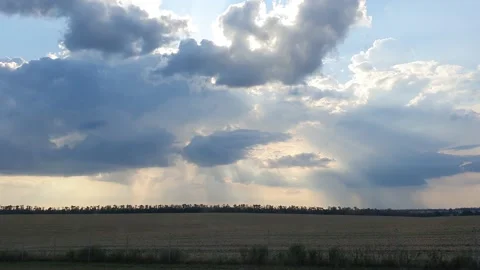 Cloudscape with large, building clouds and sunrise breaking through cloud mass Video stock 163654943