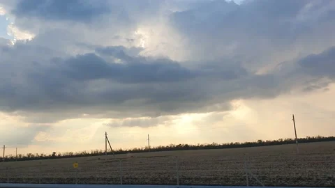 Cloudscape with large, building clouds and sunrise breaking through cloud mass Video stock 163655104