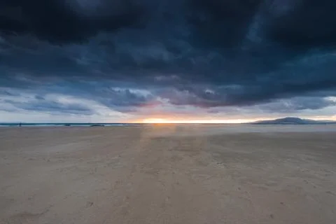 Cloudscape over beach and ocean in Spain, before storm Stock Photos