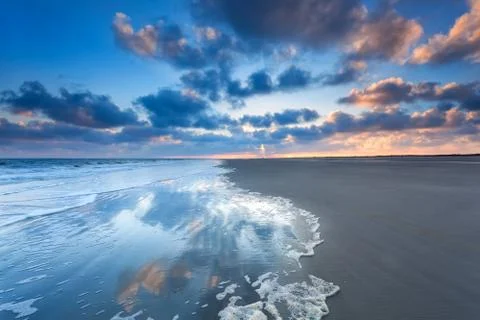 Cloudscape reflected in sea at sunrise Stock Photos