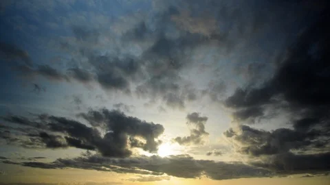 Cloudscape in timelapse with dark and golden clouds passing in front of the sun. Stock Footage 87174703