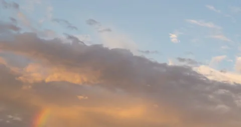 Cloudscape timelapse with rainbow below clouds, sunset day to night 4K Stock Footage 147860755