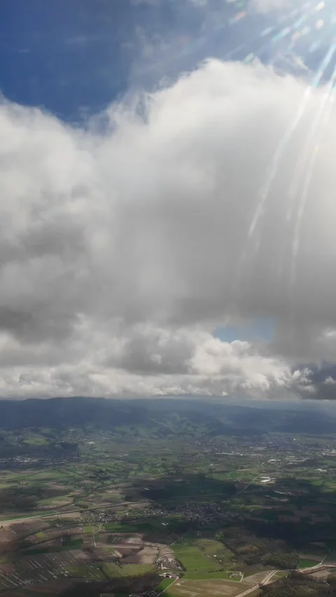 Cloudscape view from the aircraft window, flying above green landscapes, sunny Stock Footage 274201374