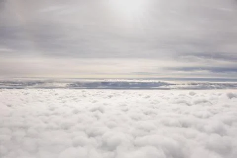 Cloudscape, view from the window of an airplane flying above the clouds. Stock Photos