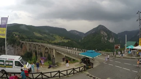 Cloudy and rainy mountains. Timelaps. Tourists walking on big bridge in mountain Stock Footage 77754187