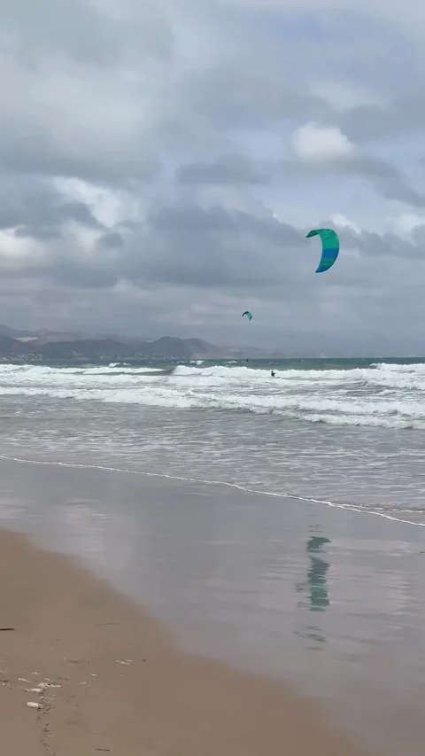 Cloudy beach scene. Rainy coast featuring flying kites and choppy waters Stock Footage 327915739