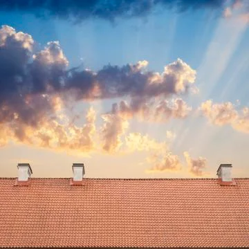 Cloudy blue sky and tiled roof top Stock Photos