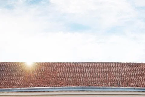 Cloudy blue sky and tiled roof top Foto stock