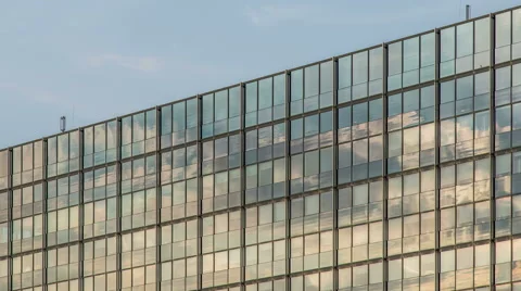 Cloudy blue sky with modern illuminated reflected glass  facade timelapse Stock Footage 53247676