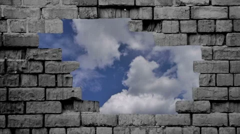 Cloudy blue sky passes behind hole in wall Stock Footage 64785826