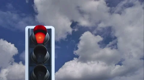 Cloudy blue sky passes behind red traffic light Stock Footage 64785880
