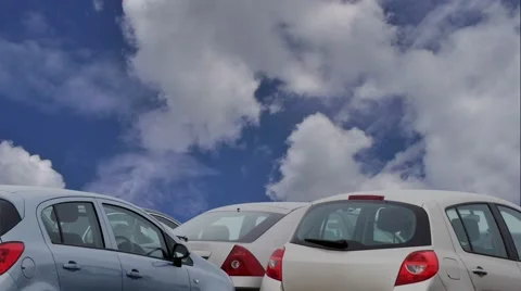 Cloudy blue sky passes over parked cars Stock Footage 64785741