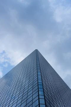 Cloudy blue sky reflection skyscraper glass exterior trees framing Stock Photos