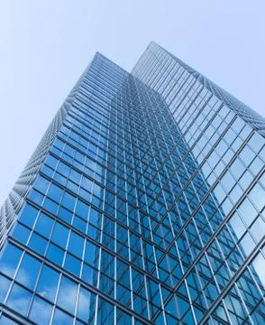 Cloudy blue sky reflection skyscraper glass exterior trees framing Stock Photos