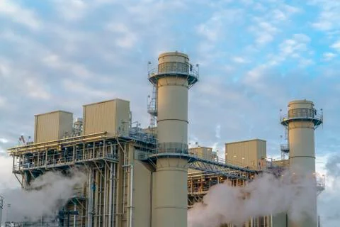 Cloudy blue sky viewed behind the towers and buildings of a Power Plant Stock Photos