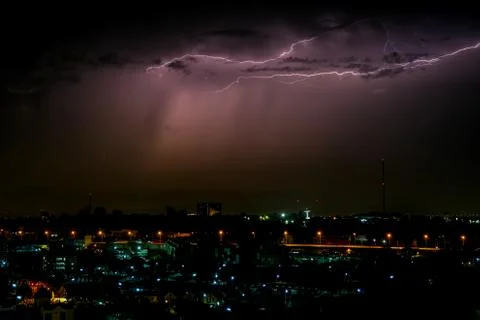 Cloudy with Bright lightning bolt strikes in the rural landscape of small cit Stock Photos