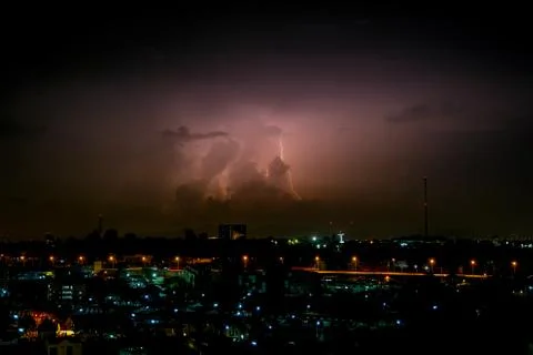 Cloudy with Bright lightning bolt strikes in the rural landscape of small cit Stock Photos