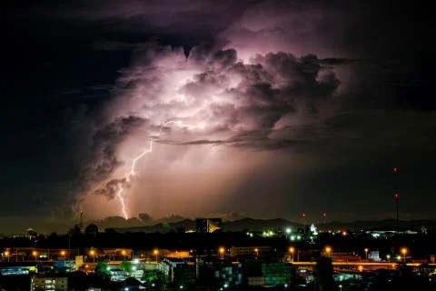 Cloudy with Bright lightning bolt strikes in the rural landscape of small cit Stock Photos