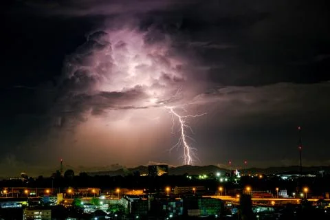 Cloudy with Bright lightning bolt strikes in the rural landscape of small cit Stock Photos