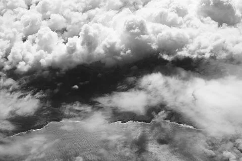Cloudy coast. Aerial view of a dramatic beautiful ocean coastline in black and Stock Photos
