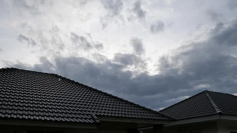 Cloudy dark sky in rainy day scene, water pouring rain falling on roof house Stock Footage 94173911