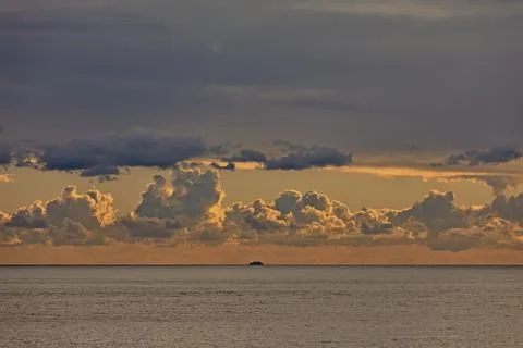 Cloudy dawn.  Ship on horizon. Stock Photos