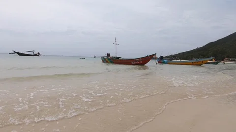 Cloudy day at Koh Phangan Beach, Thailand with Long Tail Boats Stock Footage 121891477