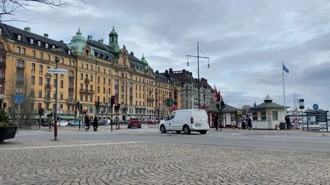 Cloudy day with strollers, cars, trams at the crossing in center of Stockholm Stock Footage 152538525