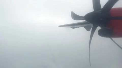 Cloudy day time sky through flying plane window sun flair  aircraft propellor Stock Footage 248960018