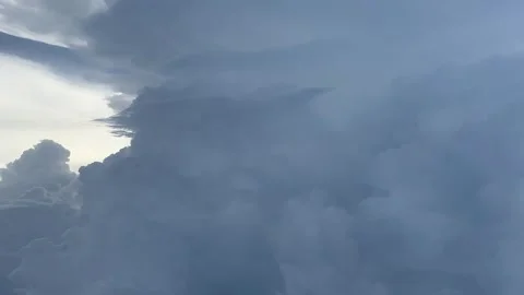 Cloudy day time sky through flying plane window sun flair aircraft Stock Footage 248960049