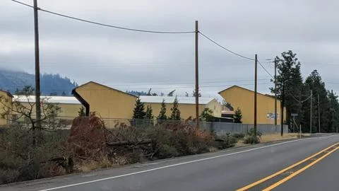Cloudy-day view of a small town lumber mill with unusual yellow structures Stock Photos