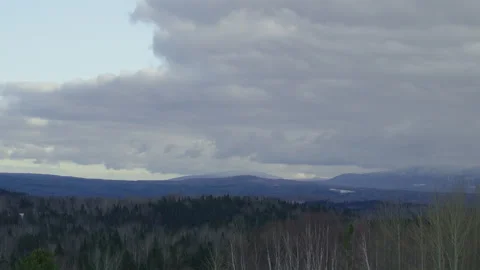 Cloudy day winter forest hill valley with windmill Stock Footage 255993846