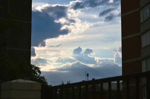 Cloudy evening landscape between two buildings in the shade Stock-Fotos