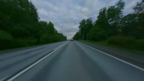 Cloudy evening skies over the interregional highway. On both sides of the road Stock Footage 157997886