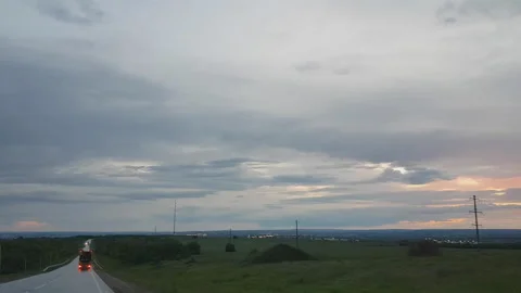 Cloudy evening sky over the road. cars go on a wet highway. Stock Footage 91201442