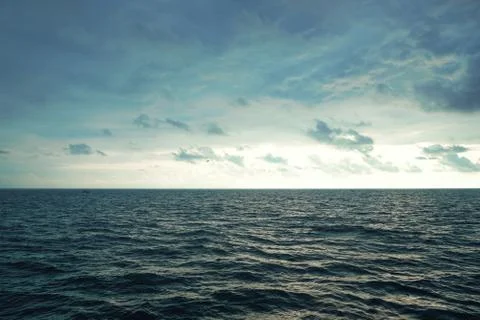 Cloudy evening sky over the sea surface of the water Stock Photos
