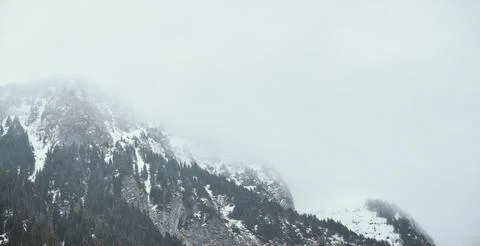 Cloudy mountain hill covered by snow Stock Photos