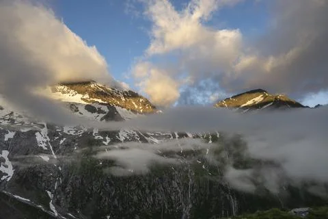 Cloudy mountain landscape in dramatic morning light, summit Hochsteller and Stock Photos