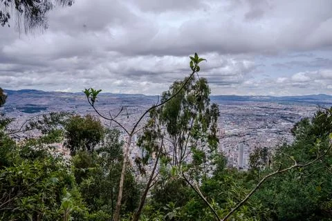Cloudy mountain overlook with forest and distant Bogota skyline Stock Photos