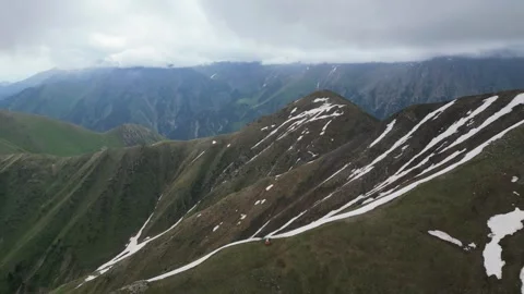 Cloudy mountain peaks with melting snow patches Stock Footage 345386662